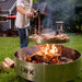 Live cook over open flame in backyard with LUX Pro Precision grill. Steaks and shish-ka-bobs grilling on the Versa Grate while chef adds seasoning to food.