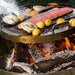 Live cook of grilled salmon and lemons on Versa Grate over open fire.