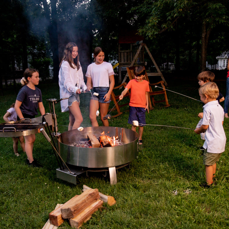 Children cooking Smores over LUX Pro Precision grill with Versa Grate rotated away from fire.